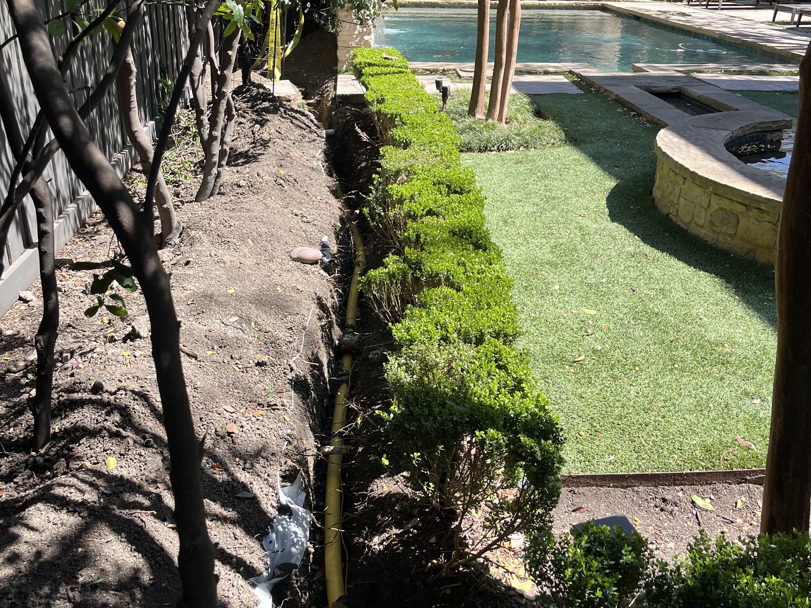 New yellow natural gas line being run in an open backyard trench