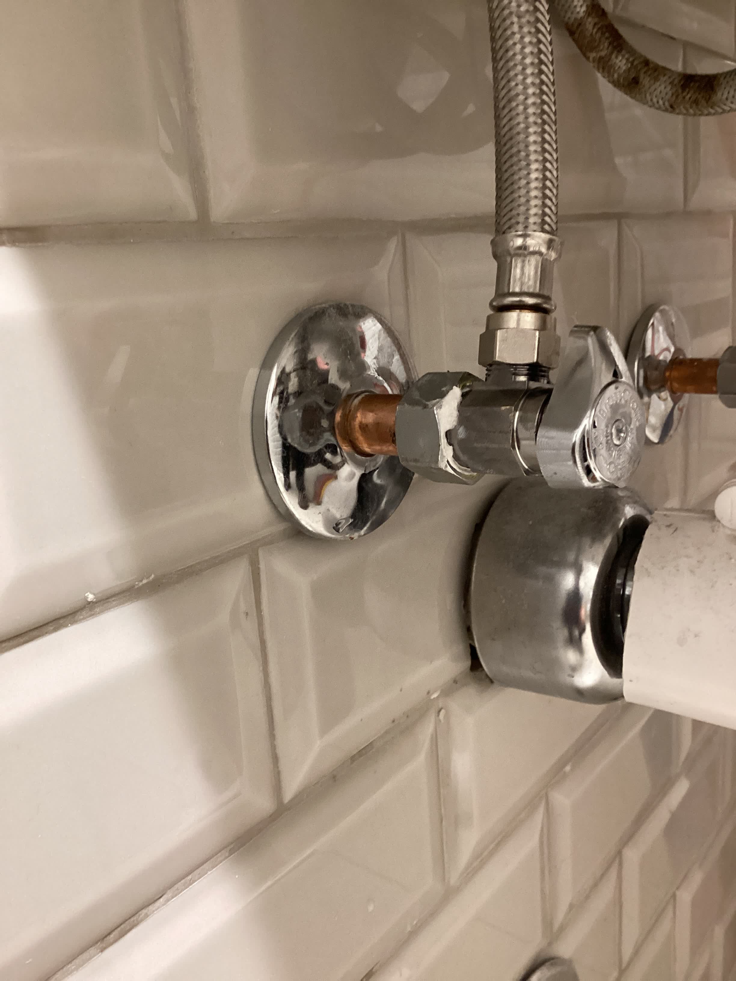 New angle stop and braided supply line fitted under a bathroom fixture
