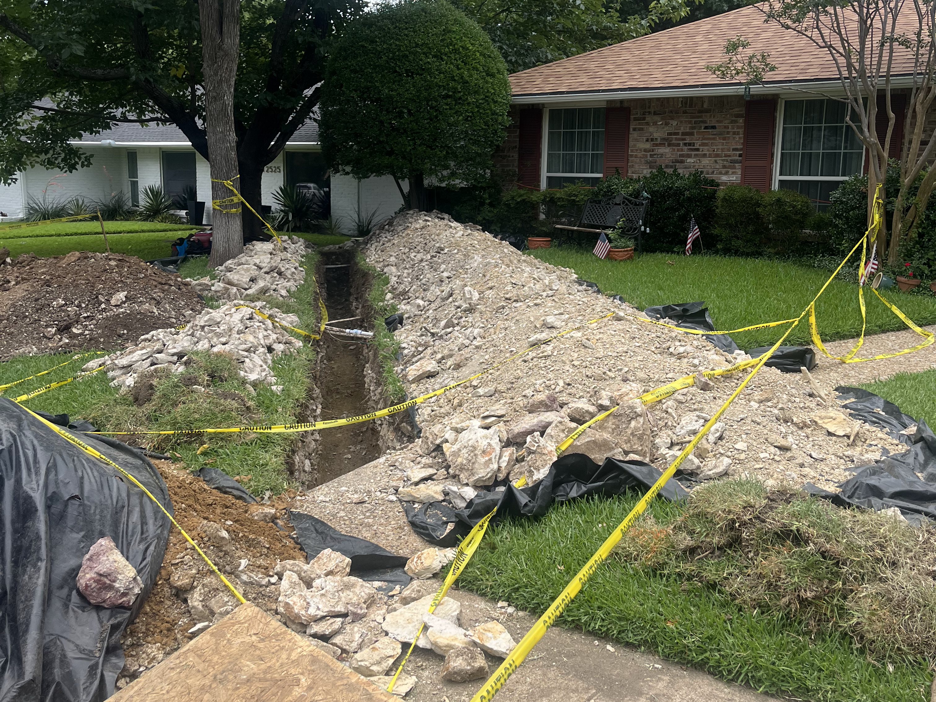 Front yard trench cut across a lawn for a sewer line replacement