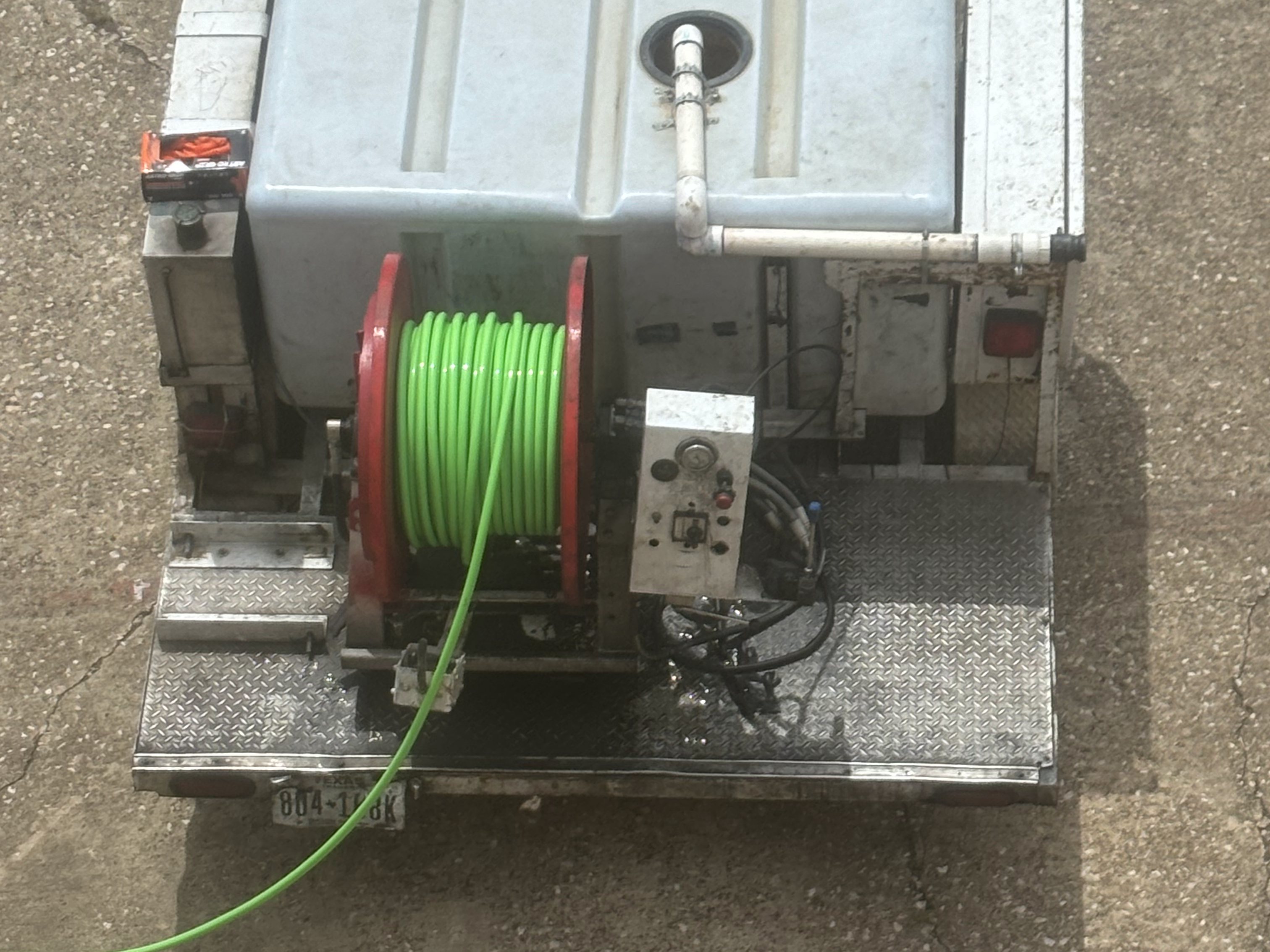 Trailer-mounted high-pressure jetter with hose reel used to clear blocked drain lines
