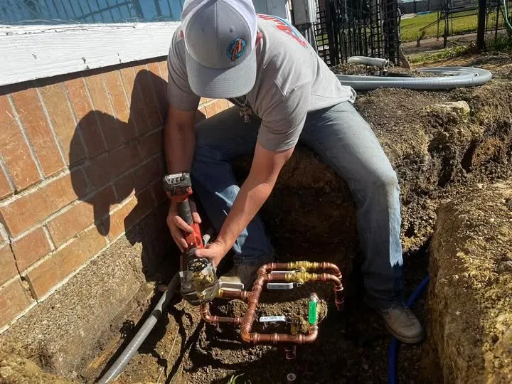 Plumber installing underground copper pipe connections